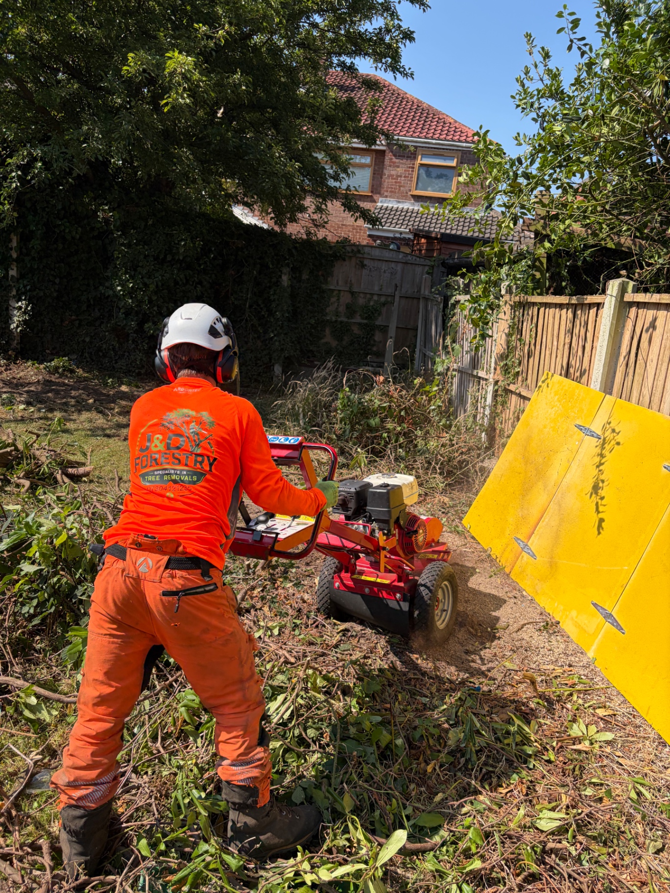 J&D Forestry operator stump grinding in a residential garden