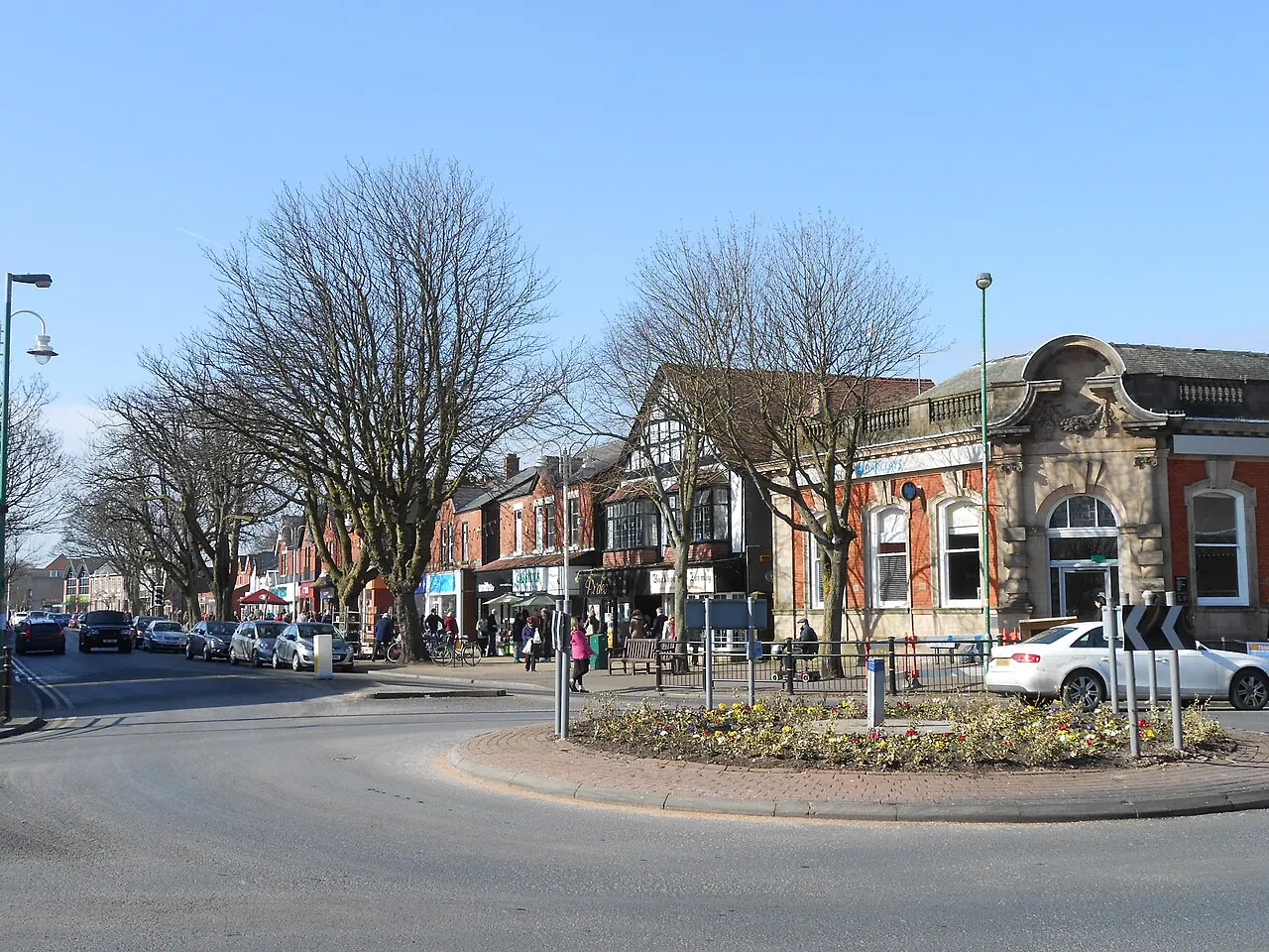 Formby village centre with shops and mature street trees
